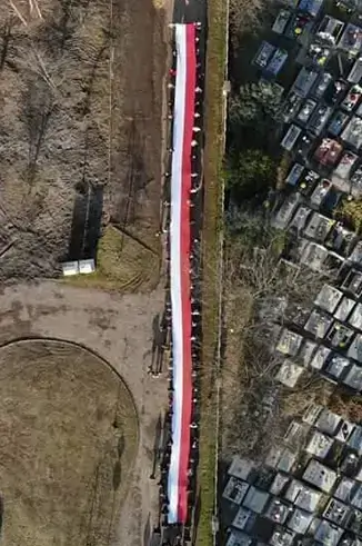 flaga polski trzymna przez wielu ludzi