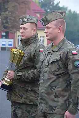 na zdjeciu widać dwuch żołnierzy jeden trzyma puchar